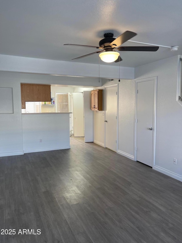 unfurnished living room with dark hardwood / wood-style floors and ceiling fan