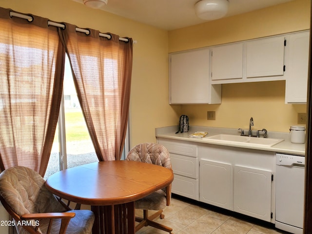 kitchen with dishwasher, sink, light tile patterned floors, and white cabinets