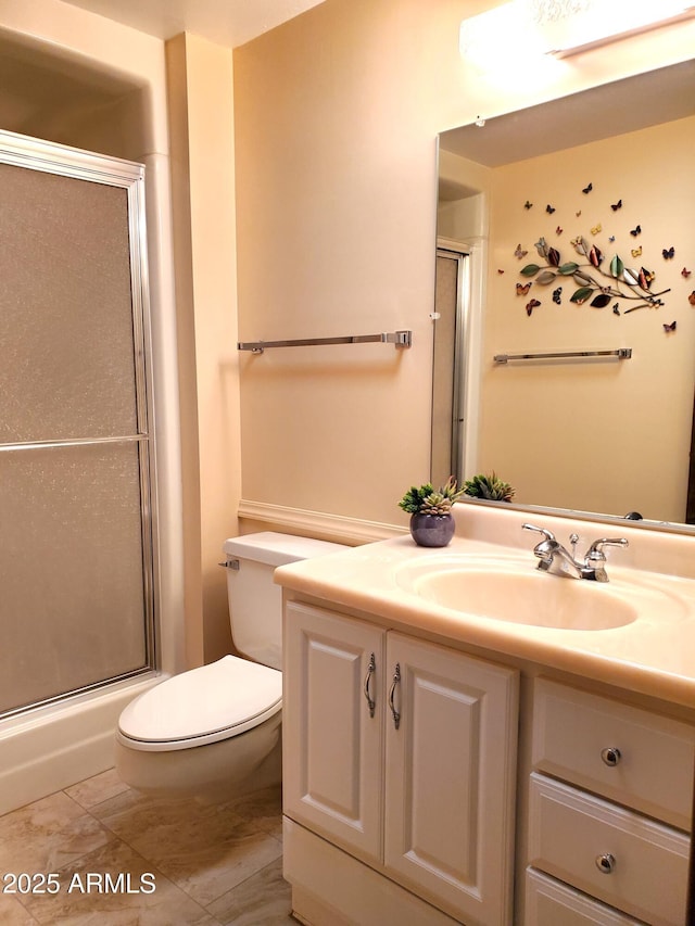 bathroom featuring a shower with door, vanity, and toilet