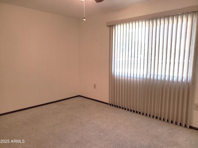 spare room with ceiling fan and light colored carpet