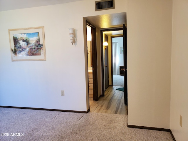 hallway featuring light carpet