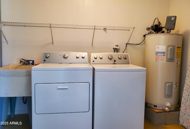 laundry area with sink, water heater, and washing machine and clothes dryer