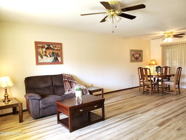 living room featuring ceiling fan and light hardwood / wood-style floors