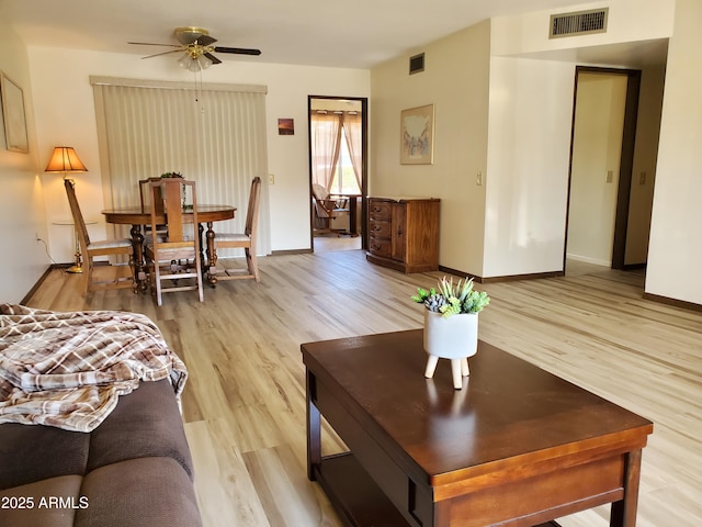 living room featuring ceiling fan and light hardwood / wood-style flooring