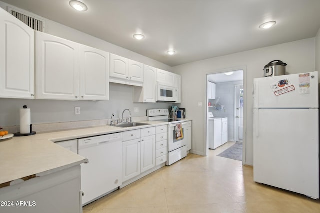 kitchen featuring white appliances, sink, independent washer and dryer, white cabinetry, and light tile patterned floors