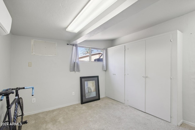 basement with an AC wall unit and light colored carpet