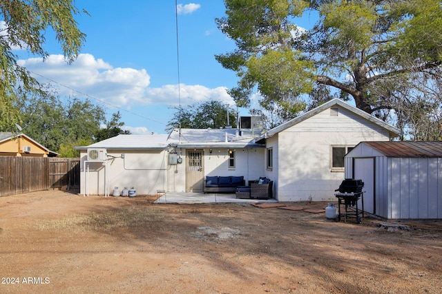 back of property featuring a patio, an outdoor living space, and a storage shed