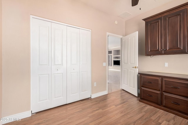 unfurnished bedroom featuring light hardwood / wood-style flooring, a closet, and ceiling fan