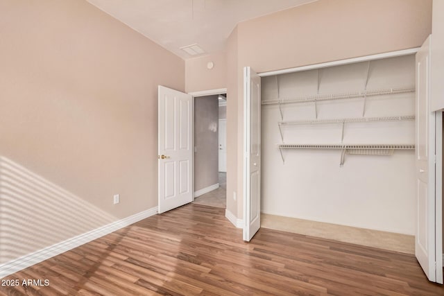 unfurnished bedroom featuring wood-type flooring and a closet