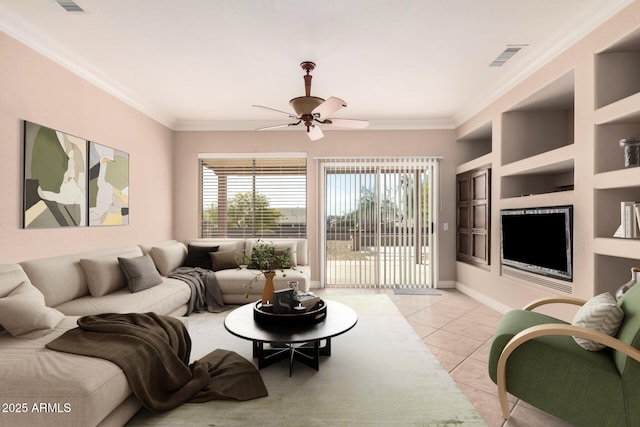 living room featuring built in shelves, ceiling fan, ornamental molding, and light tile patterned floors