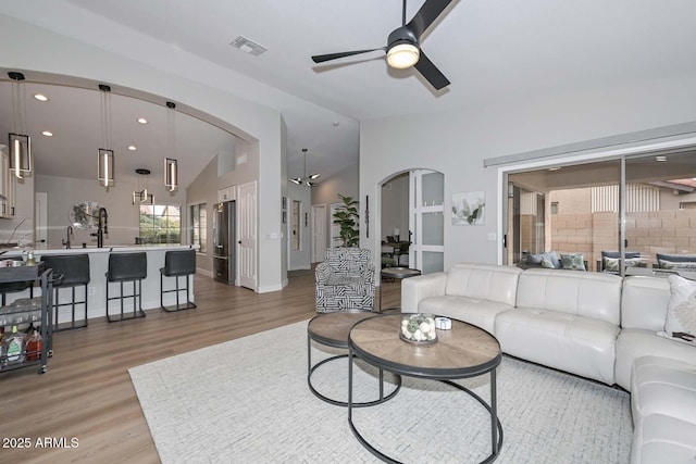 living room with hardwood / wood-style flooring, lofted ceiling, and ceiling fan