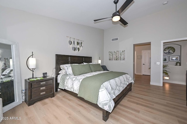 bedroom featuring lofted ceiling, ceiling fan, and light wood-type flooring