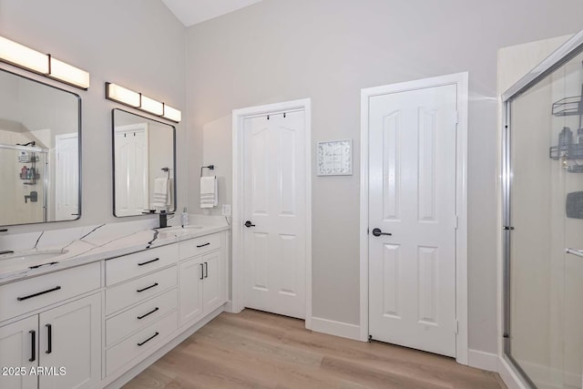 bathroom featuring a shower with door, wood-type flooring, and vanity