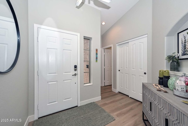 foyer with ceiling fan, light hardwood / wood-style floors, and vaulted ceiling