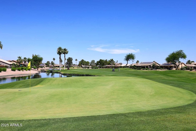 view of property's community with a water view and a lawn