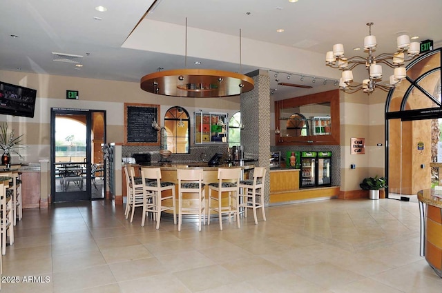 kitchen with a chandelier, a kitchen breakfast bar, decorative light fixtures, and decorative backsplash