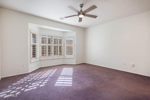 empty room featuring ceiling fan and dark colored carpet