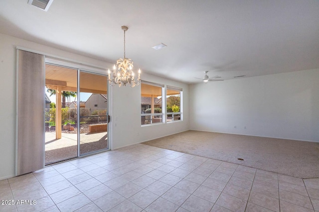 carpeted spare room with ceiling fan with notable chandelier