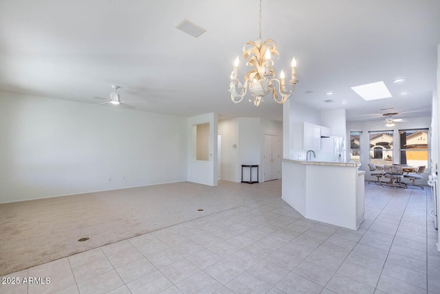 kitchen featuring ceiling fan with notable chandelier, white refrigerator with ice dispenser, white cabinets, decorative light fixtures, and light colored carpet