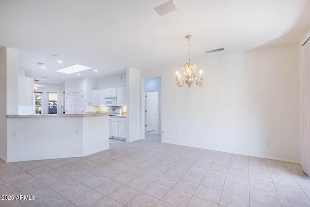 interior space with white cabinetry, pendant lighting, a notable chandelier, and kitchen peninsula