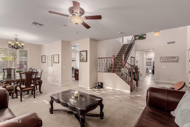 carpeted living room featuring ceiling fan with notable chandelier