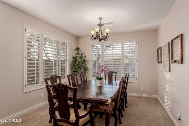 carpeted dining room featuring a notable chandelier