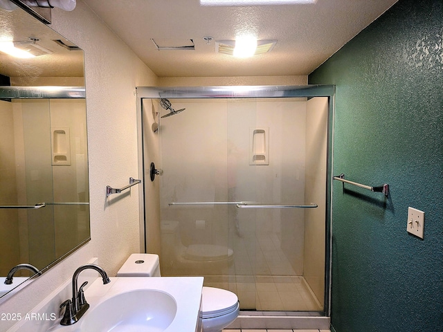 full bath with a textured wall, toilet, a stall shower, vanity, and a textured ceiling