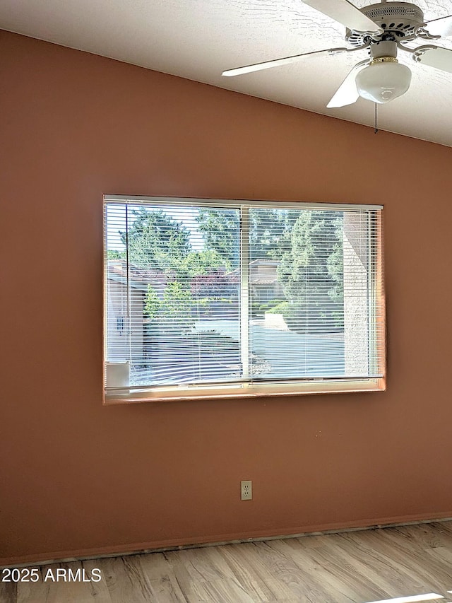 unfurnished room featuring light wood-style floors, a ceiling fan, and baseboards
