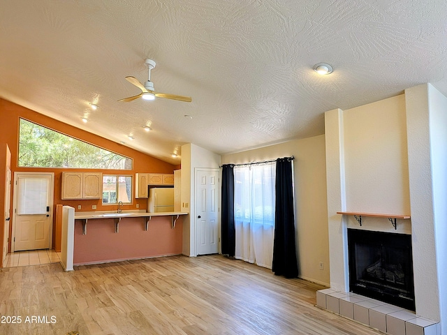 kitchen with white fridge, ceiling fan, light wood-style floors, a breakfast bar area, and a peninsula