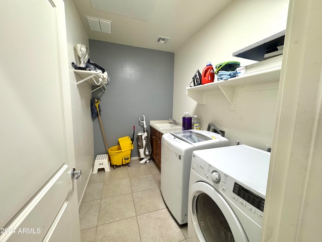 laundry room with cabinets, sink, light tile patterned floors, and washing machine and dryer