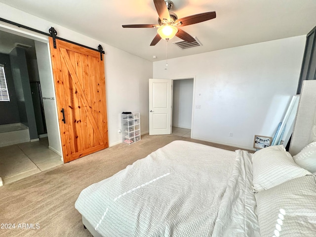 bedroom featuring a barn door, ceiling fan, and light colored carpet