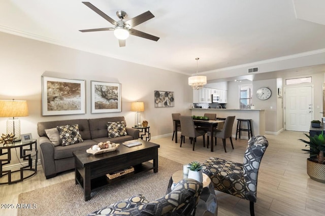 living area featuring crown molding, light wood finished floors, visible vents, baseboards, and ceiling fan with notable chandelier