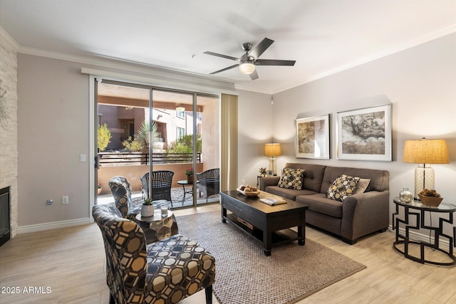 living area featuring a stone fireplace, ornamental molding, light wood-style flooring, and a ceiling fan