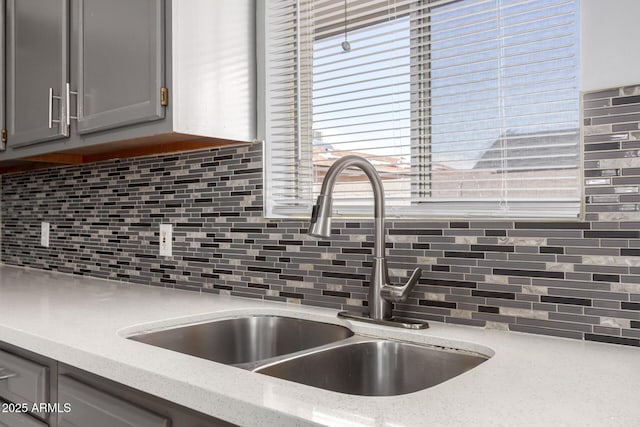 2936 E Beck Ln, Phoenix, AZ 85032 - kitchen featuring light stone countertops, a sink, gray cabinetry, and tasteful backsplash