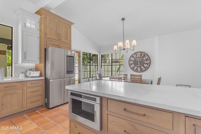 kitchen with vaulted ceiling, light brown cabinetry, a chandelier, and appliances with stainless steel finishes