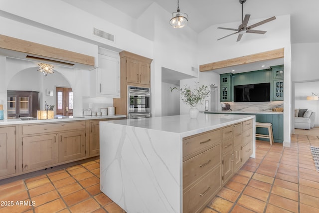 kitchen with open floor plan, light brown cabinetry, visible vents, and light countertops
