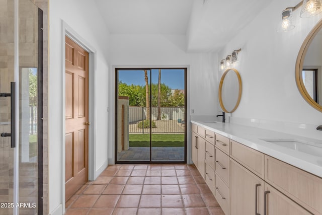 full bathroom with a sink, double vanity, and tiled shower