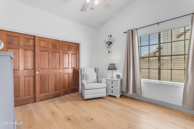 living area featuring light wood-style floors, lofted ceiling, and a ceiling fan