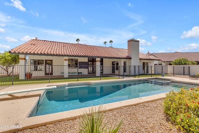 view of swimming pool featuring a pool with connected hot tub, a patio, and fence