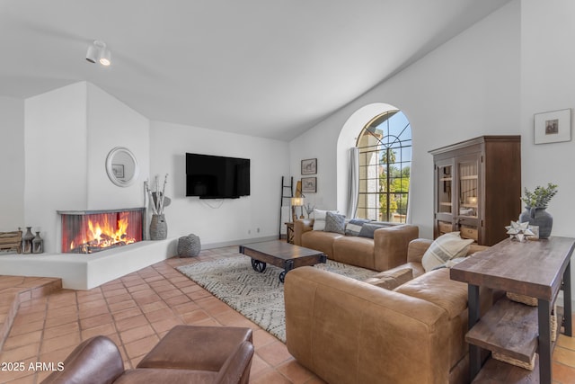 tiled living area featuring high vaulted ceiling and a multi sided fireplace