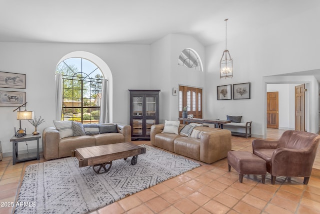living room featuring an inviting chandelier, lofted ceiling, and light tile patterned floors
