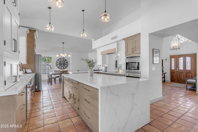 kitchen with double oven, visible vents, light tile patterned floors, a chandelier, and high vaulted ceiling