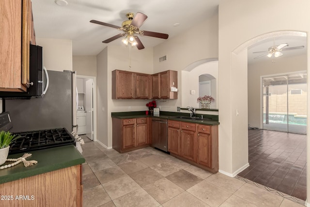 16288 W Hadley St, Goodyear, AZ 85338 - kitchen featuring ceiling fan, stainless steel dishwasher, dark countertops, black gas range, and high vaulted ceiling