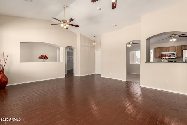 16288 W Hadley St, Goodyear, AZ 85338 - unfurnished living room with ceiling fan, lofted ceiling, arched walkways, and dark wood-style floors