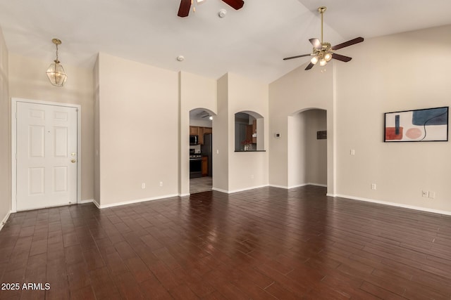 16288 W Hadley St, Goodyear, AZ 85338 - unfurnished living room with a ceiling fan, arched walkways, dark wood-style floors, and high vaulted ceiling