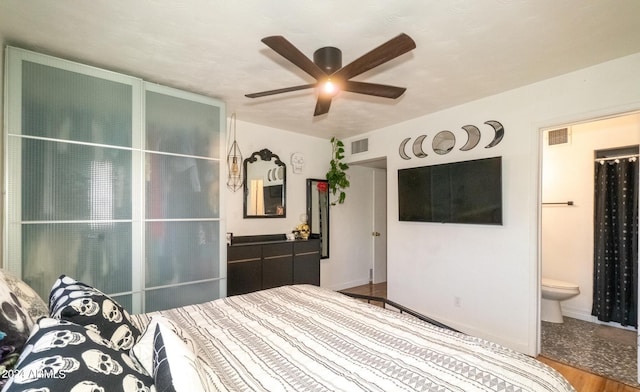 unfurnished bedroom featuring ceiling fan, ensuite bathroom, and hardwood / wood-style flooring