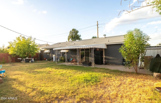 back of house featuring a lawn and a patio area