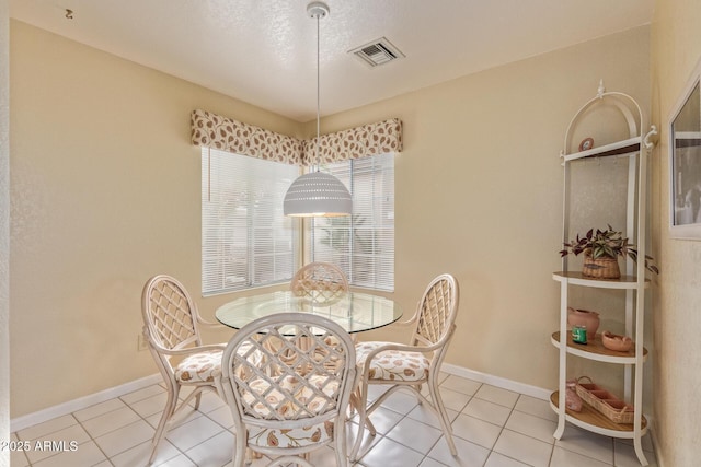 dining area with light tile patterned flooring, visible vents, and baseboards