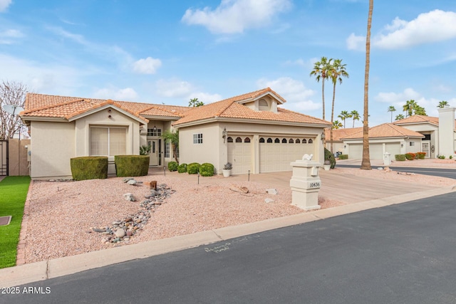 mediterranean / spanish-style home featuring stucco siding, concrete driveway, a tile roof, and an attached garage