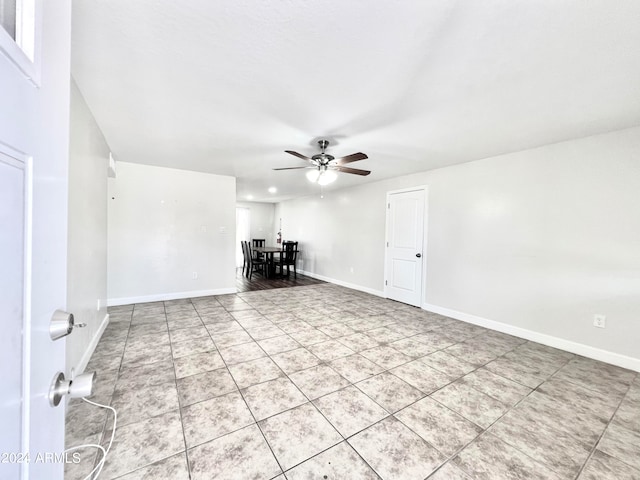 tiled spare room featuring ceiling fan